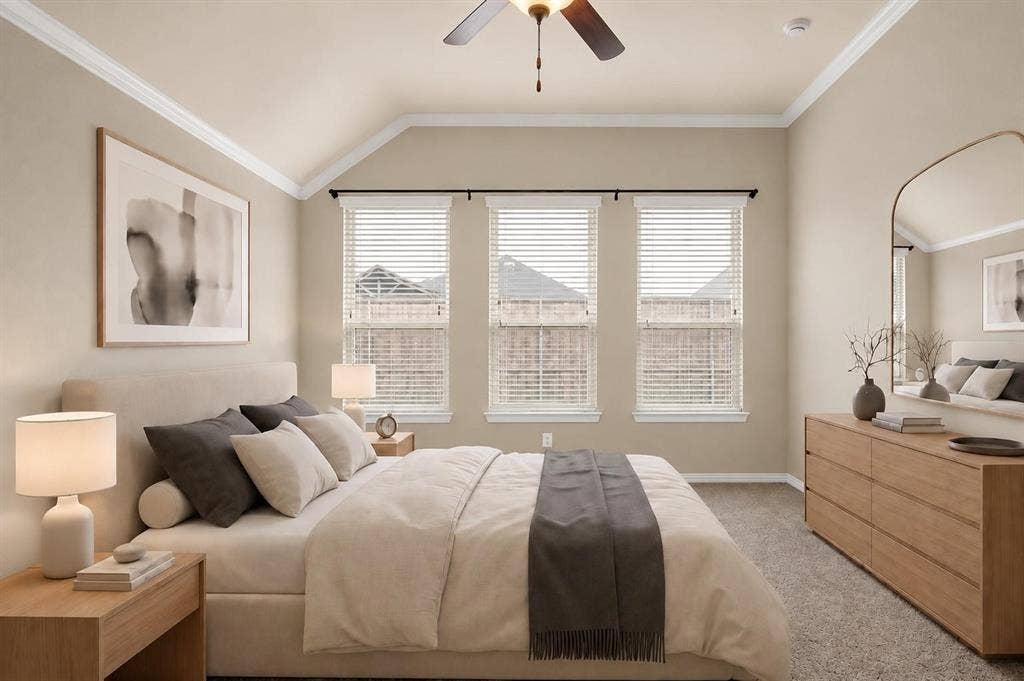 Bedroom featuring vaulted ceilings with crown molding, three large windows, a ceiling fan, and carpet flooring