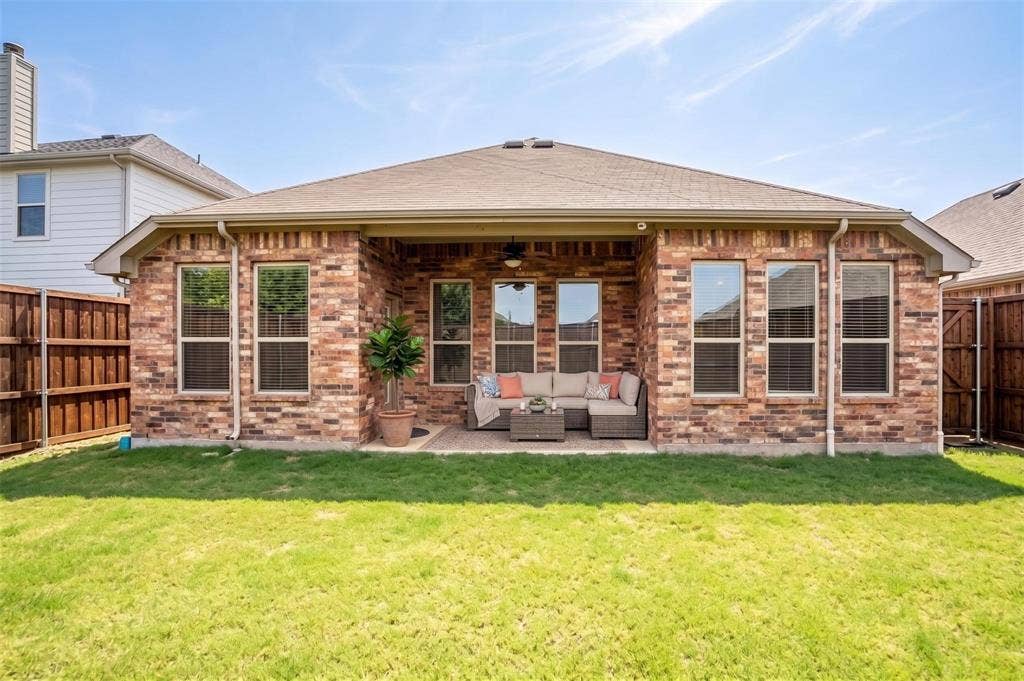 Brick exterior with a covered patio, featuring a ceiling fan and recessed lighting