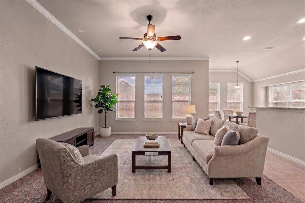 Open-concept living area with tray ceiling, recessed lighting, and ceiling fan