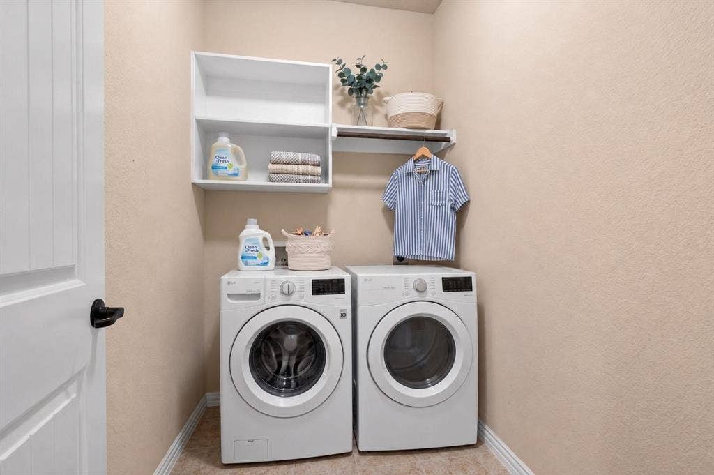 Dedicated laundry area featuring white shelving, a hanging rod, and textured wall finish