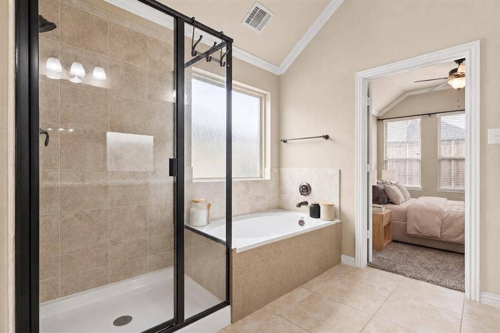 Bathroom featuring a tiled shower with a frameless glass enclosure, a built-in bathtub with a tiled surround, and ceramic tile flooring