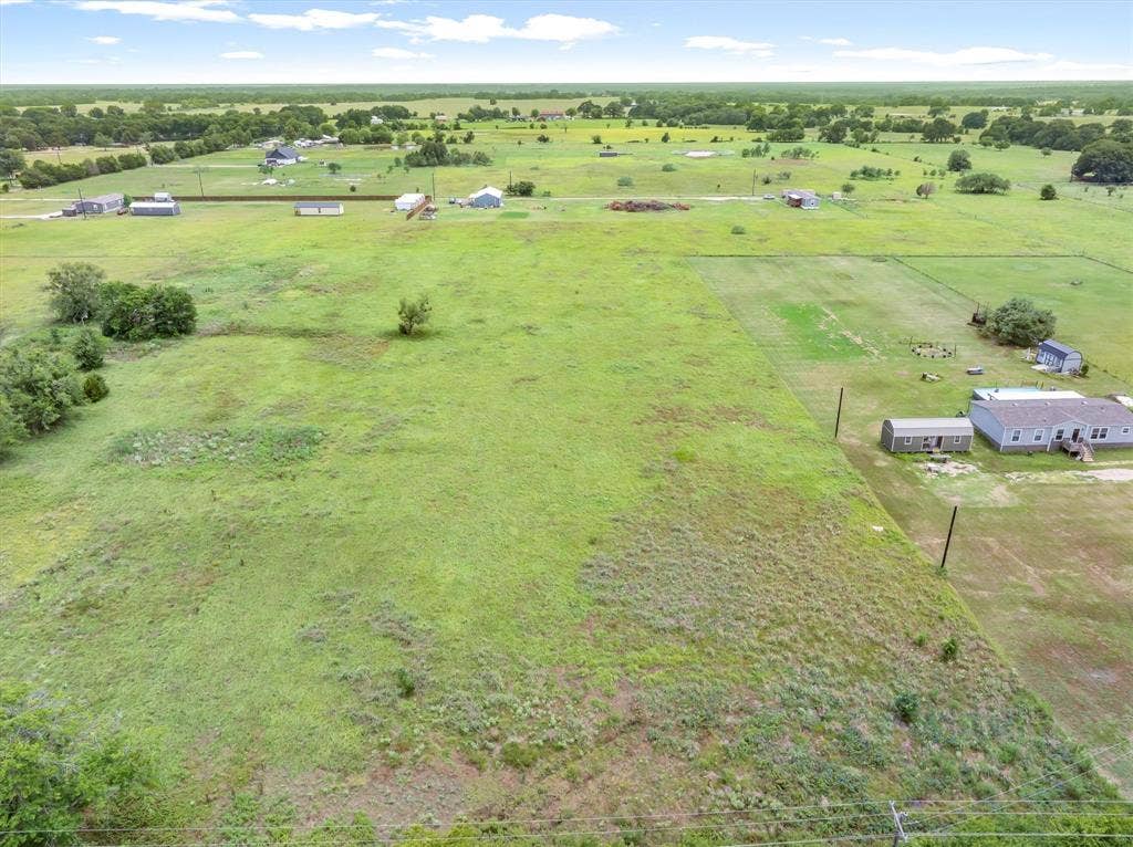 Lot 3R W. Cedar PKWY, Kemp, TX 75143 Expansive green acreage featuring a scattered tree line and distant structures under a broad sky