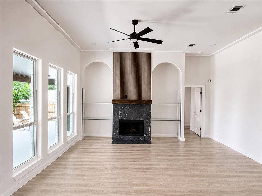 1706 Fairhaven Drive, Mansfield, TX 76063 Light wood-finish flooring complements a modern fireplace with a dark stone surround and wood mantel