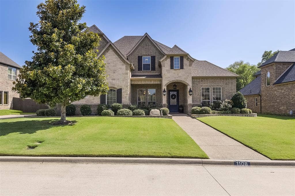 Stone and brick exterior with dark shutters and a distinguished front entry
