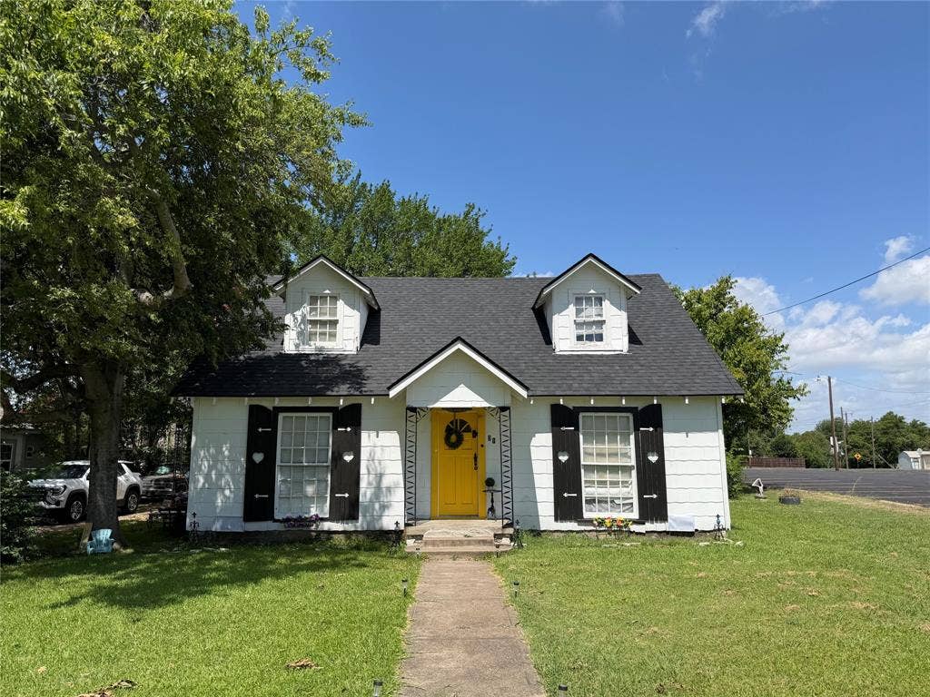 311 S Ebrite Street, Mesquite, TX 75149 White siding exterior with a dark shingle roof and two prominent dormer windows