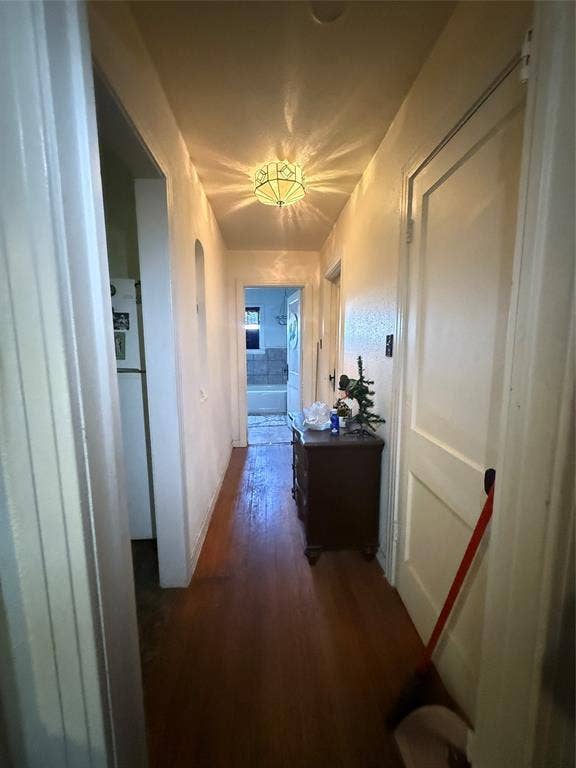 311 S Ebrite Street, Mesquite, TX 75149 Hallway featuring wood-finish flooring, a decorative ceiling-mounted light fixture, and arched wall openings