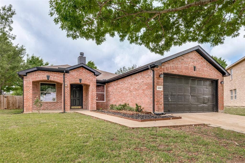Brick facade residence featuring a covered front entry, an attached two-car garage, and a manicured lawn