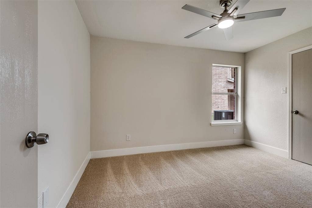 Carpeted room featuring a ceiling fan with integrated lighting, a window, and neutral wall tones