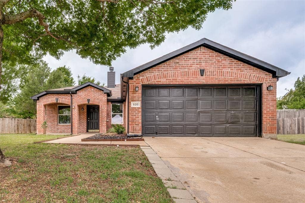 Brick exterior with dark trim and a two-car garage