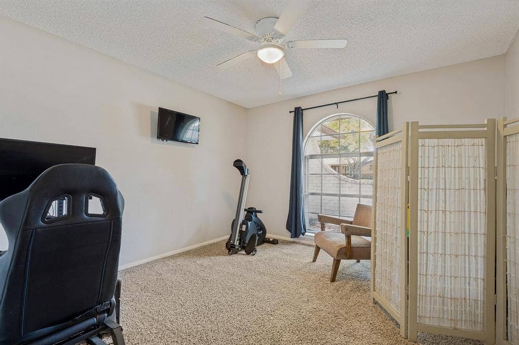 404 Green River Trail, Fort Worth, TX 76103 Spacious room featuring neutral carpeting, light-toned walls, and an arched window with dark drapery