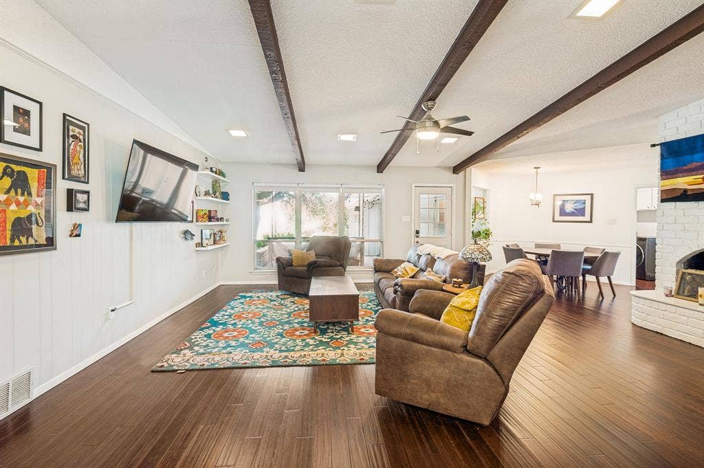 404 Green River Trail, Fort Worth, TX 76103 Spacious living area featuring wood-finish flooring, white paneled walls, and exposed wood ceiling beams