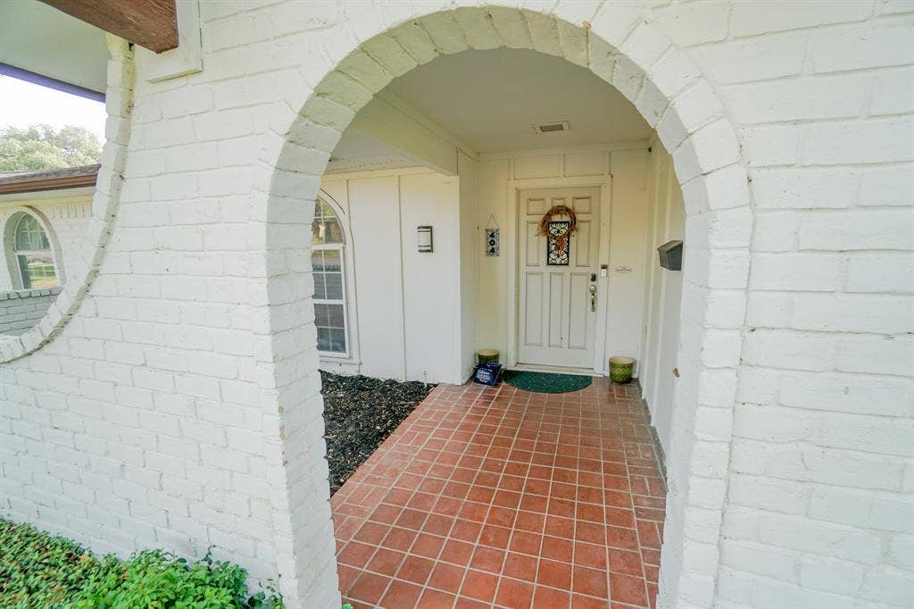 404 Green River Trail, Fort Worth, TX 76103 Arched brick entryway featuring a terracotta tile floor and white painted brick 404 Green River Trail, Fort Worth, TX 76103