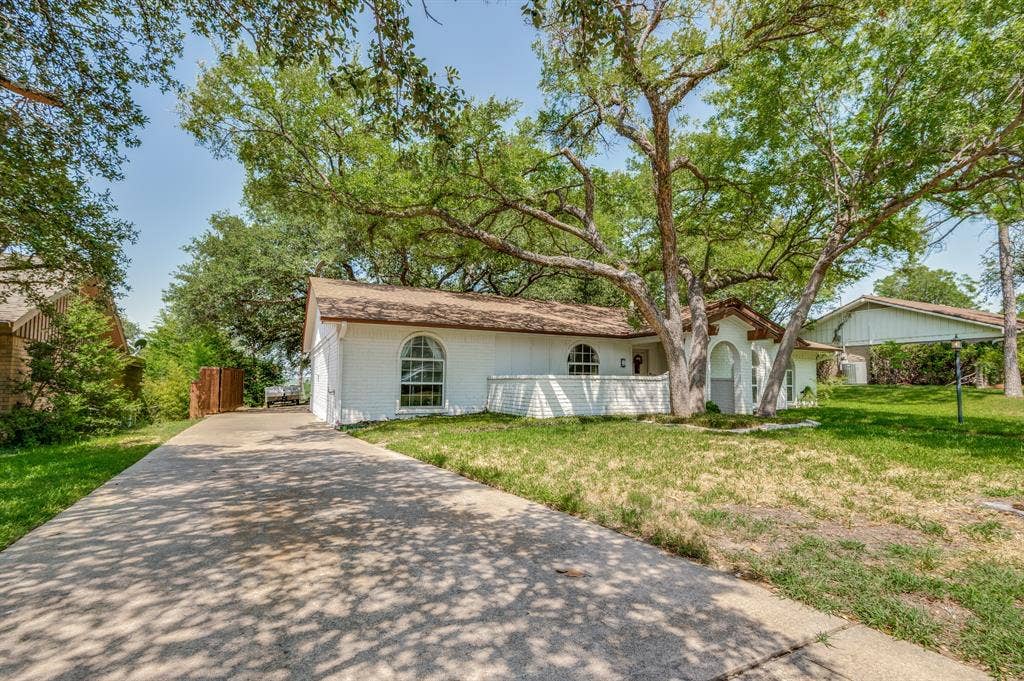 404 Green River Trail, Fort Worth, TX 76103 White brick exterior with a brown shingle roof