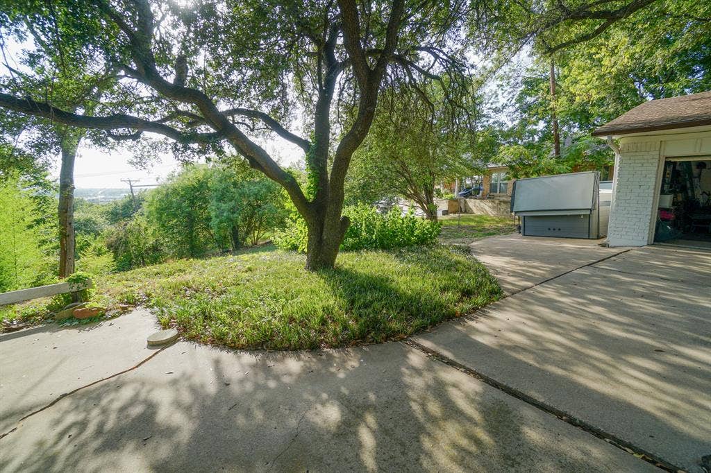 404 Green River Trail, Fort Worth, TX 76103 Mature trees providing natural shade over a concrete driveway
