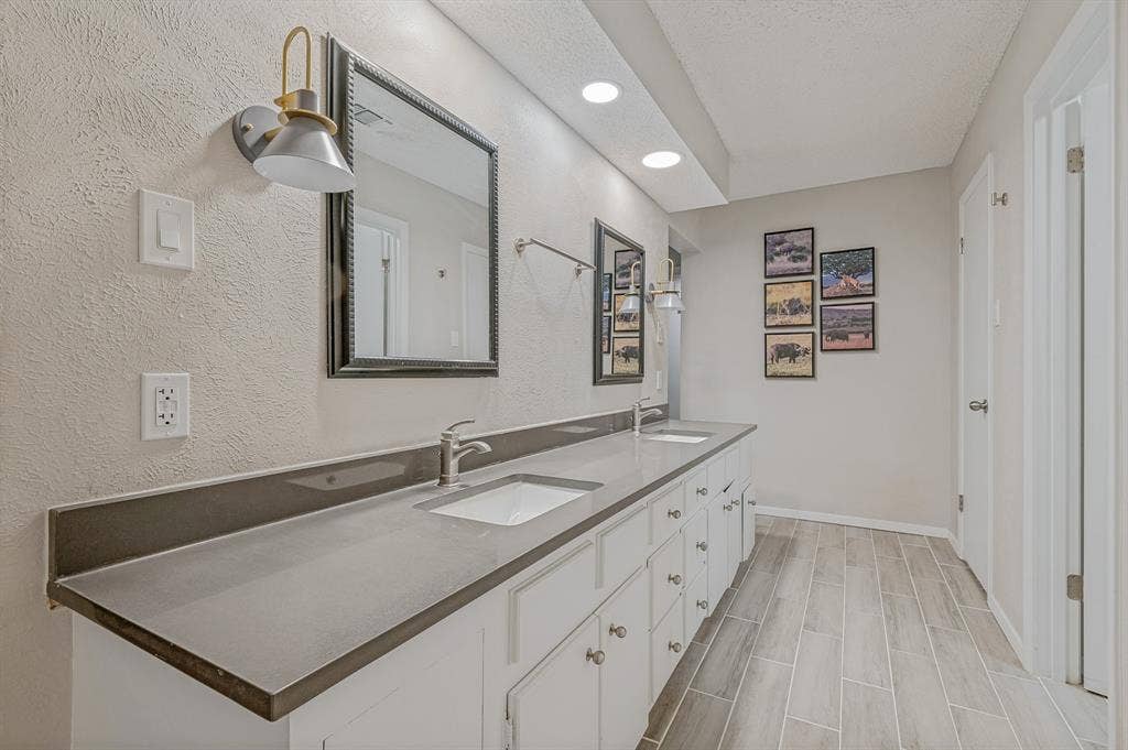 404 Green River Trail, Fort Worth, TX 76103 Dual vanity with white cabinetry, integrated sinks, and brushed nickel faucets