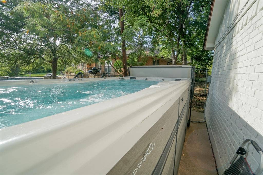 404 Green River Trail, Fort Worth, TX 76103 Swim spa featuring integrated hot tub, clear water, and a protective cover