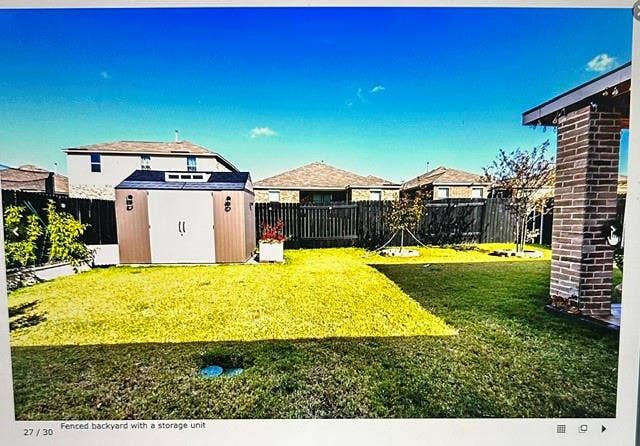 4220 Calla Drive, Forney, TX 75126 Expansive green lawn with a brown and white storage shed, surrounded by dark wood privacy fencing
