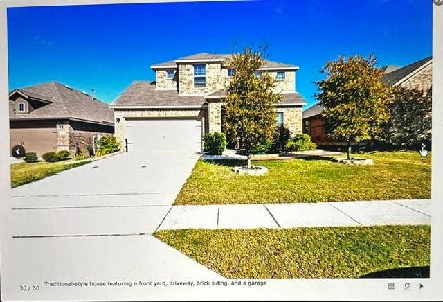 4220 Calla Drive, Forney, TX 75126 Traditional-style house featuring a front yard, driveway, brick siding, and a garage