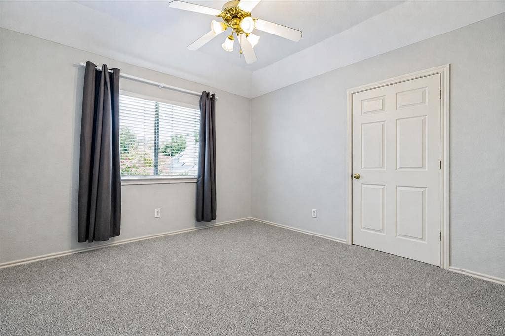 110 Falcon Creek Drive, McKinney, TX 75072 Carpeted room featuring a ceiling fan, a window with horizontal blinds, a paneled interior door, and light gray wall finishes