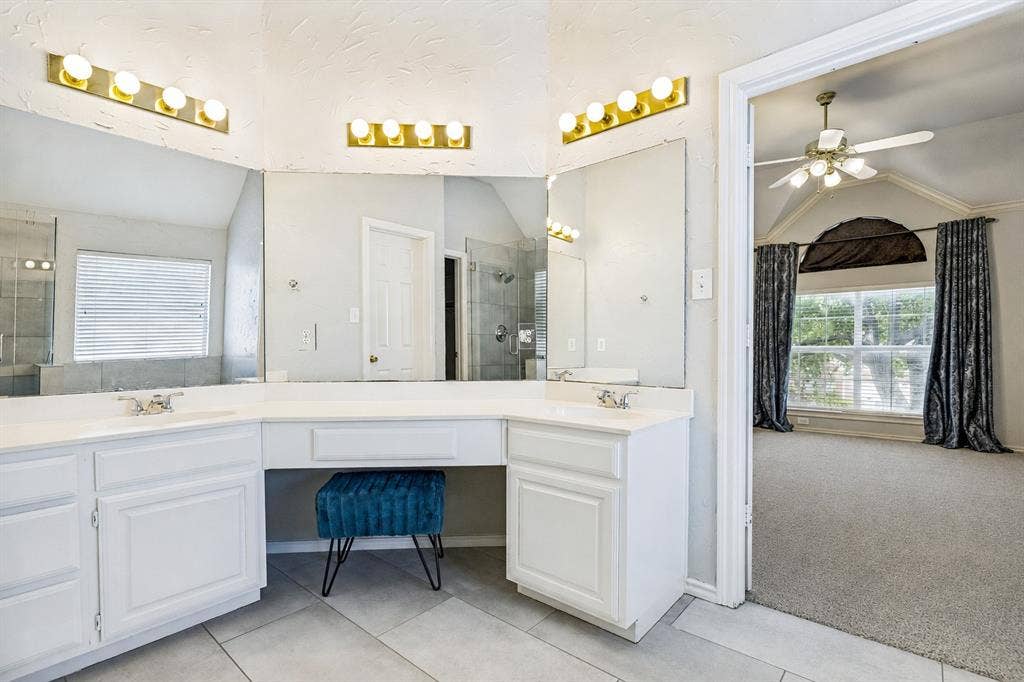 110 Falcon Creek Drive, McKinney, TX 75072 Double vanity with white cabinetry, integrated sinks, and contemporary gold-finish lighting fixtures