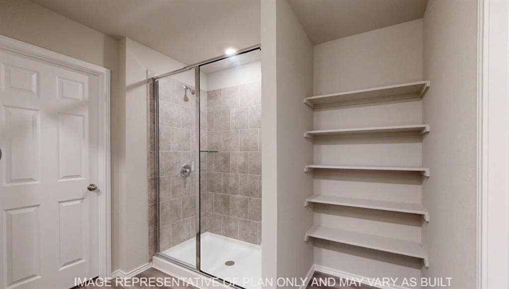 10325 Altair Drive, Waco, TX 76708 Walk-in shower with tiled surround and glass enclosure, complemented by recessed shelving for storage