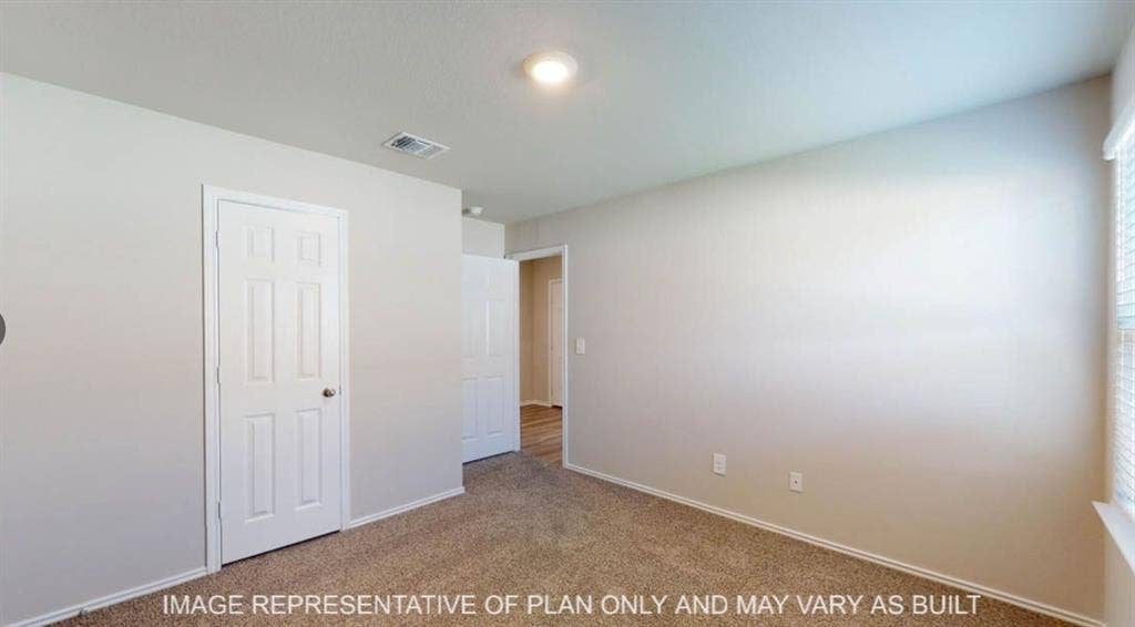 10317 Altair Drive, Waco, TX 76708 Carpeted room with light neutral wall paint, white trim, and a white paneled door