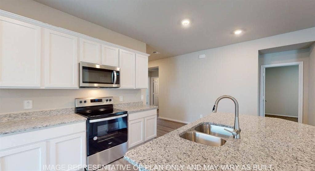 10317 Altair Drive, Waco, TX 76708 Kitchen featuring an island with a double basin stainless steel sink and a gooseneck faucet