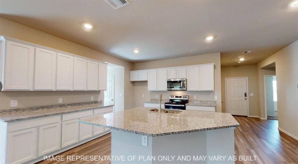 10317 Altair Drive, Waco, TX 76708 Kitchen featuring an expansive island with a stainless steel undermount sink, granite-style countertops, white shaker cabinetry, stainless steel appliances, and wood-finish flooring