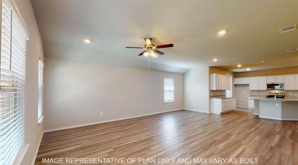 10317 Altair Drive, Waco, TX 76708 Open-concept living space featuring wood-finish flooring, vaulted ceilings, and recessed lighting