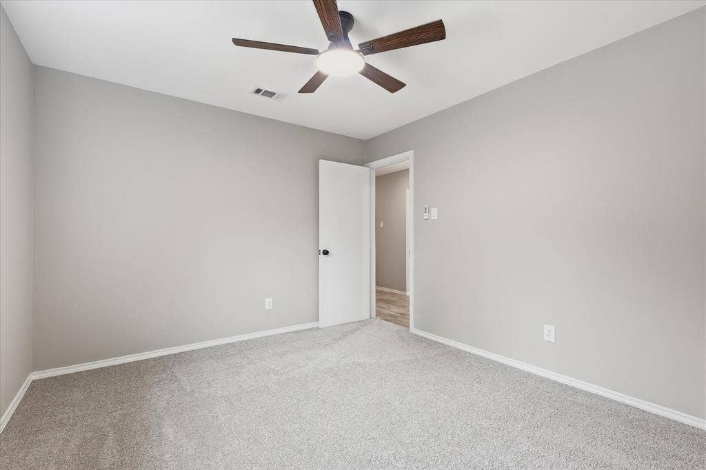 857 Twilight Trail, Grapevine, TX 76051 Spacious room featuring light gray wall paint, gray carpeting, white baseboards, and a ceiling fan with integrated lighting