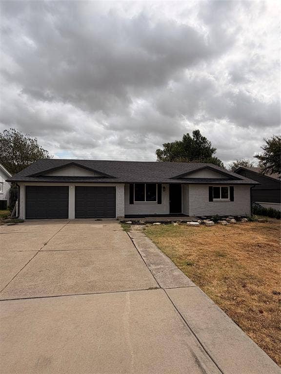 857 Twilight Trail, Grapevine, TX 76051 White brick exterior featuring a dark asphalt shingle roof, two-car garage with dark doors, and a concrete driveway