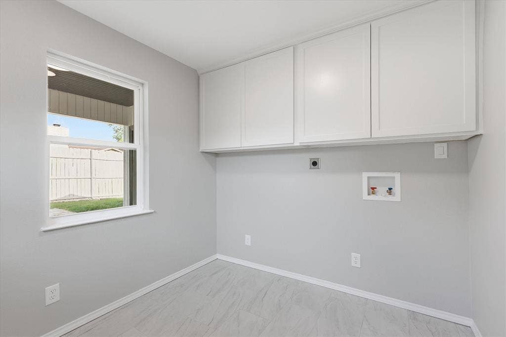 857 Twilight Trail, Grapevine, TX 76051 Laundry area featuring overhead white cabinetry, a single window, and light-toned wood-finish flooring