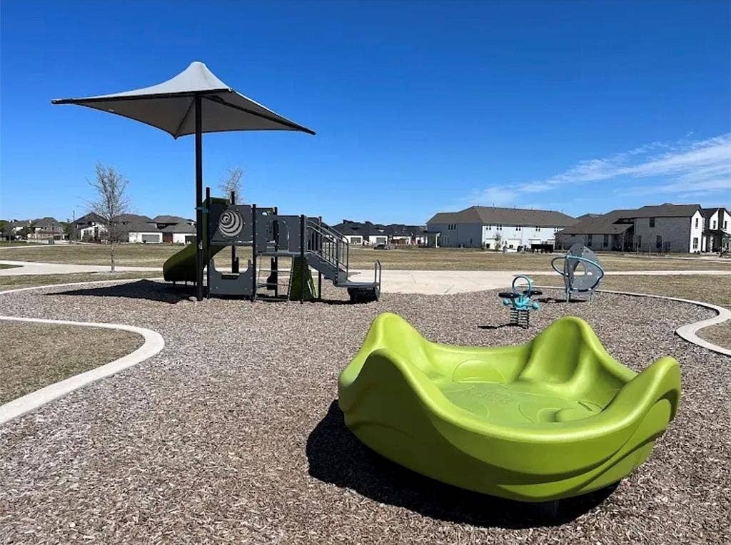11346 Sugarlands Drive, Frisco, TX 75035 Community playground featuring modern play equipment, a protective shade structure, and a wood chip surface