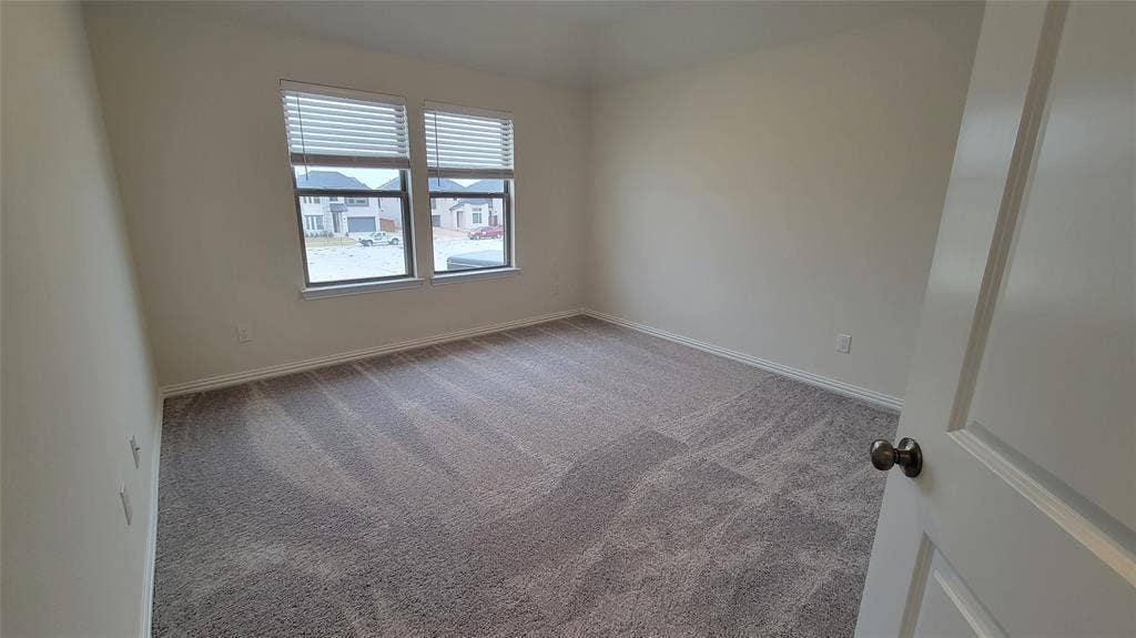 11346 Sugarlands Drive, Frisco, TX 75035 Spacious room featuring neutral carpeting, light-toned walls, and twin windows with horizontal blinds