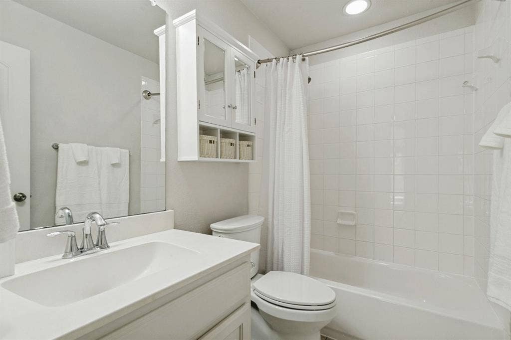 White bathroom vanity with integrated sink and chrome faucet