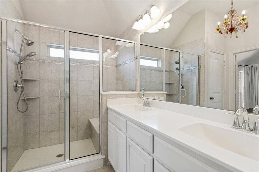 Bathroom featuring a glass-enclosed shower with a built-in bench and tiled walls