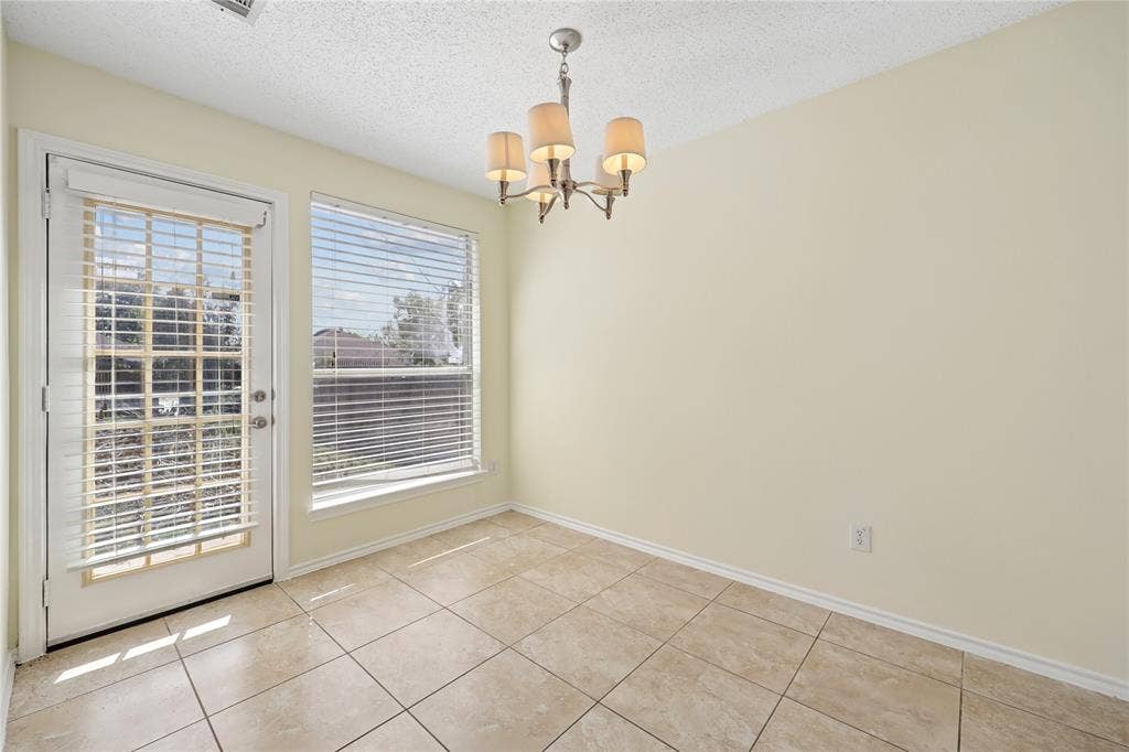 113 Bridlegate Drive, McKinney, TX 75069 Neutral-toned ceramic tile flooring, five-light traditional chandelier, multi-pane glass door, and large rectangular window with horizontal blinds