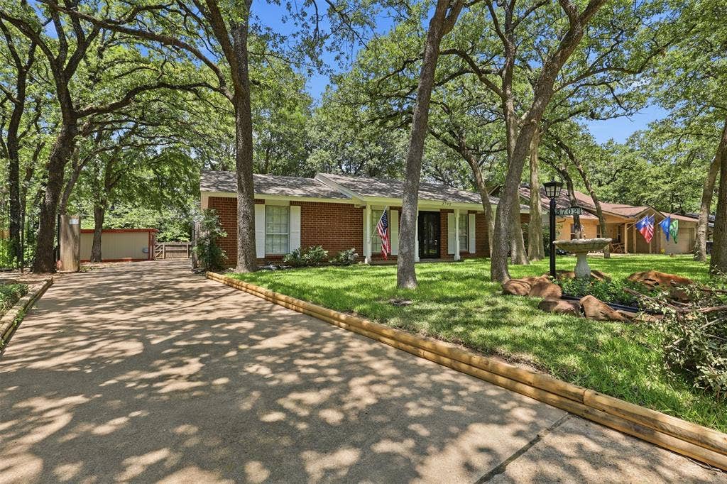 3702 Hastings Drive, Arlington, TX 76013 Charming single-story brick home in Arlington, TX 76013, surrounded by mature shade trees with an extended driveway leading to the attached garage