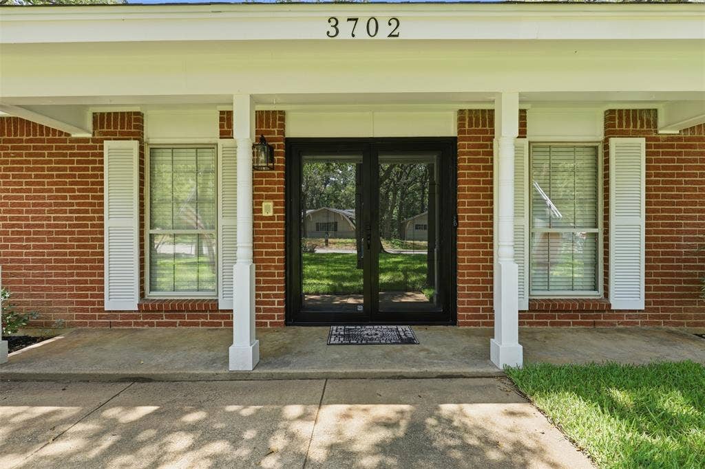 3702 Hastings Drive, Arlington, TX 76013 Welcoming covered front porch with entry door, classic brick exterior, and traditional architectural details