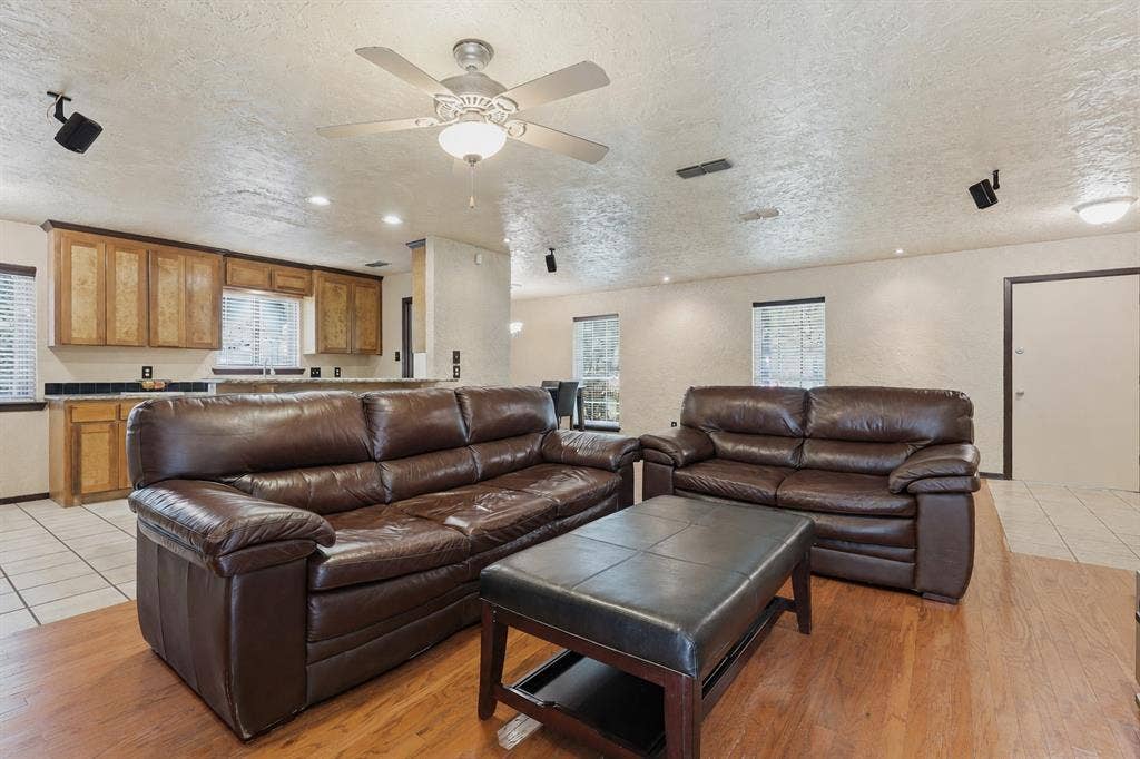 3702 Hastings Drive, Arlington, TX 76013 Expansive living and dining space with wood flooring, recessed lighting, fireplace, breakfast bar, and an open connection to the kitchen