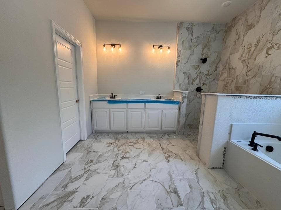809 Zachary Michael Court, Springtown, TX 76082 Dual vanity with white cabinetry, tile flooring, wall-mounted light fixtures, and a soaking tub