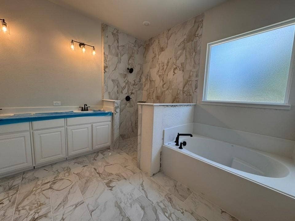 809 Zachary Michael Court, Springtown, TX 76082 Spacious bathroom featuring a built-in soaking tub, a separate walk-in shower with tiled walls, and a dual vanity with white cabinetry
