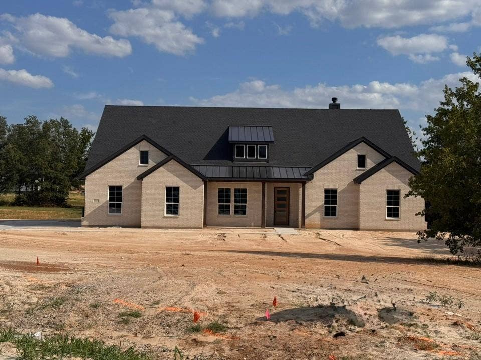 809 Zachary Michael Court, Springtown, TX 76082 Light brick exterior with a dark shingle roof and a covered entry