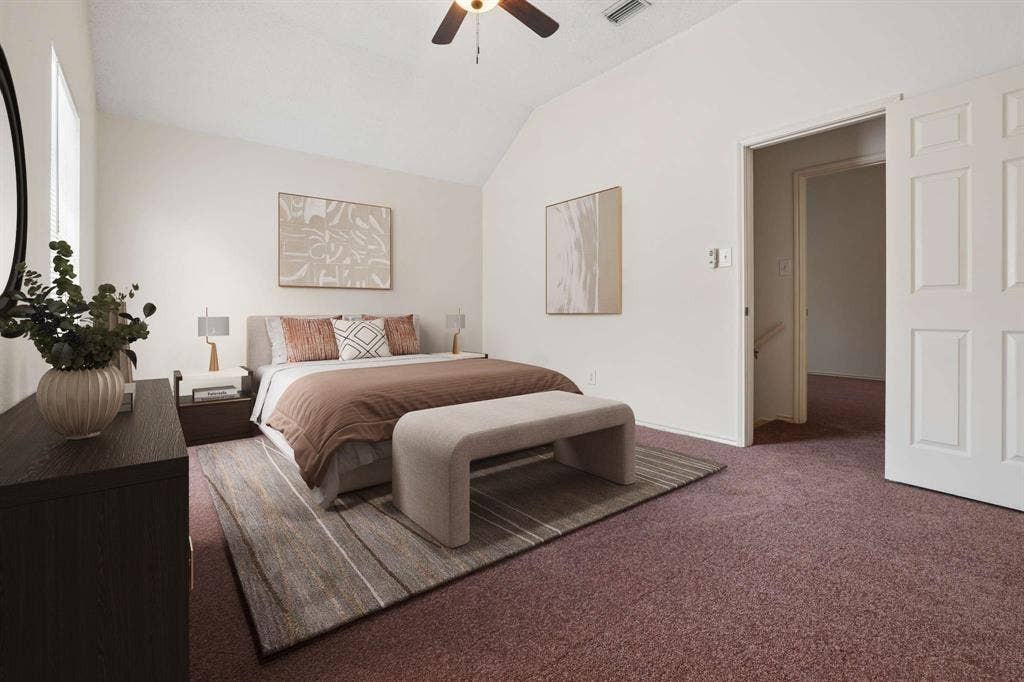 Vaulted ceiling bedroom featuring neutral wall tones, a ceiling fan, plush carpeting, and a six-panel interior door
