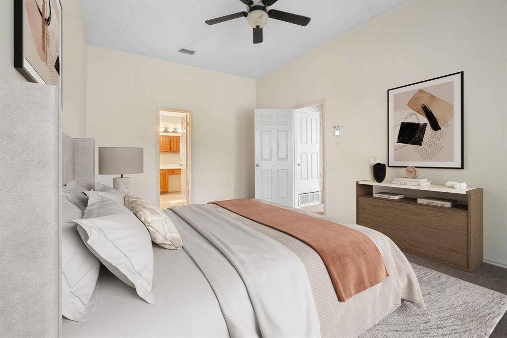 Vaulted ceilings with a ceiling fan, light-toned wall finishes, and carpeted flooring
