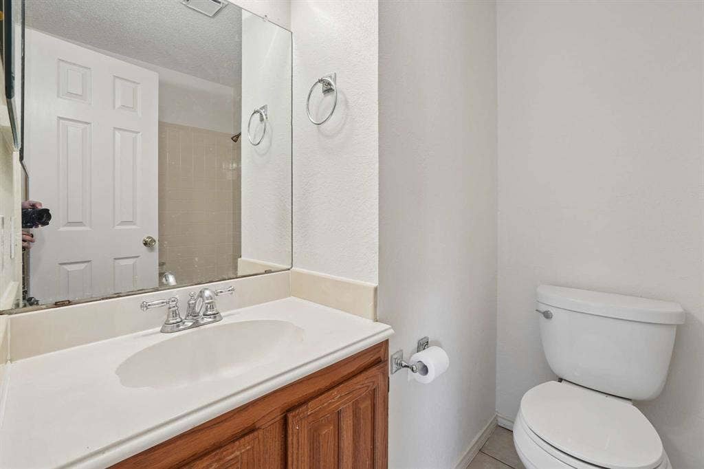 Bathroom vanity featuring an integrated sink, polished chrome faucet, and a wood-finish cabinet