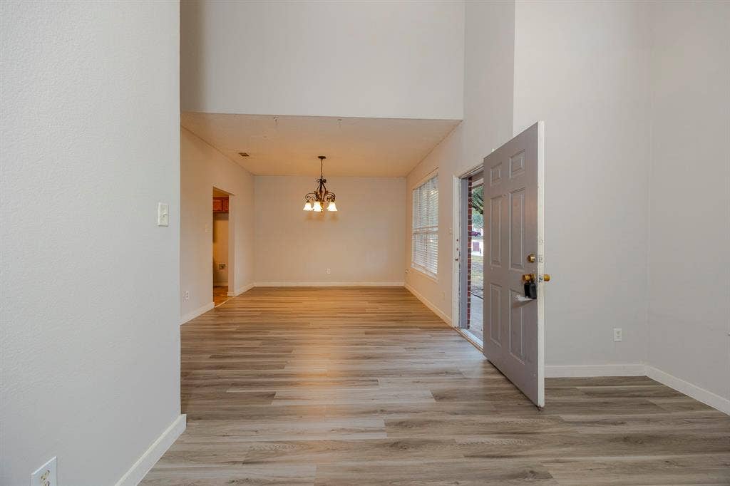 12475 Cajun Drive, Frisco, TX 75035 Vaulted ceiling, wood-finish flooring, paneled front door, multi-pane windows, and a chandelier-style light fixture