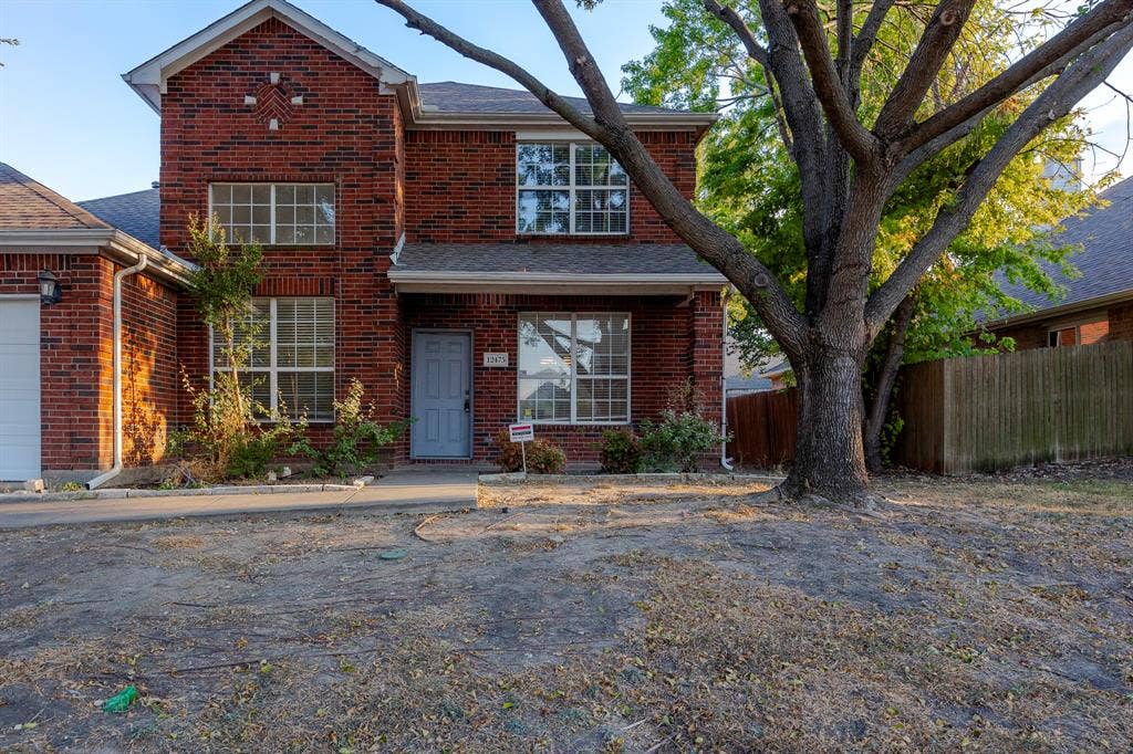 12475 Cajun Drive, Frisco, TX 75035 Brick facade residence featuring multiple windows, an attached garage, and a mature front yard tree