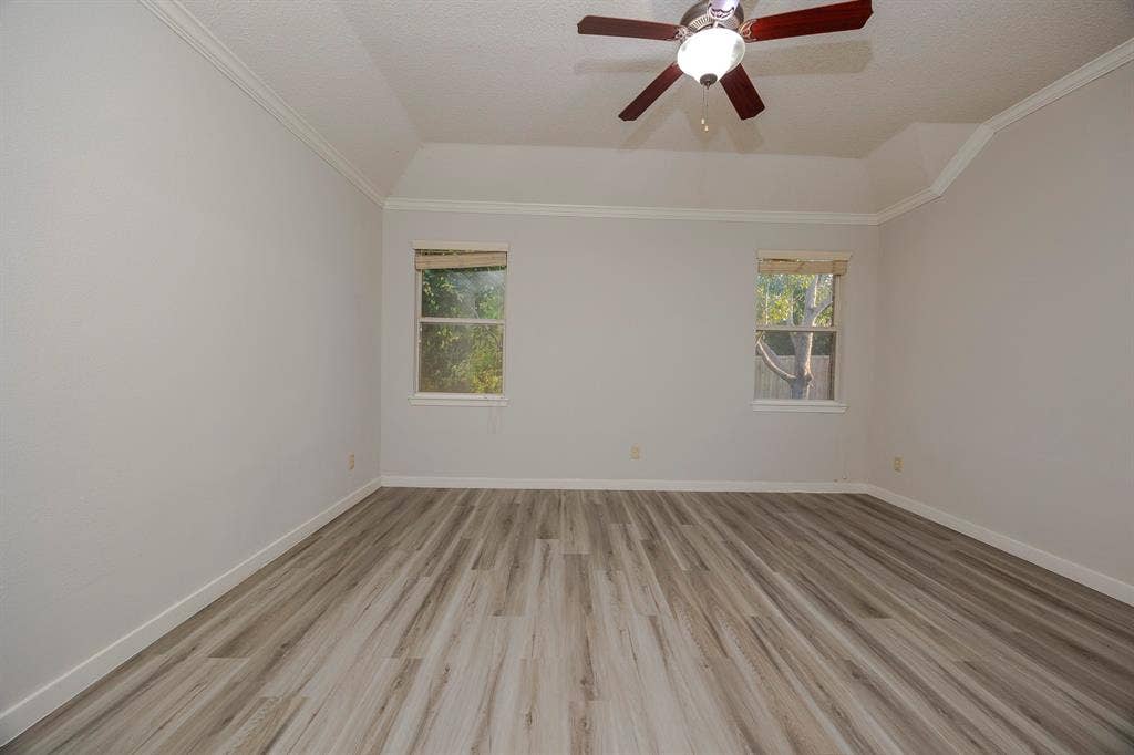 12475 Cajun Drive, Frisco, TX 75035 Recessed ceiling with an attached ceiling fan, crown molding, two windows with blinds, and wood-finish flooring