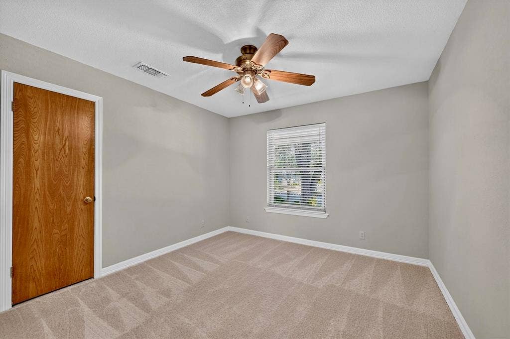 3310 Raintree Drive, Plano, TX 75074 Spacious secondary bedroom with fresh carpet, neutral décor, and abundant natural light